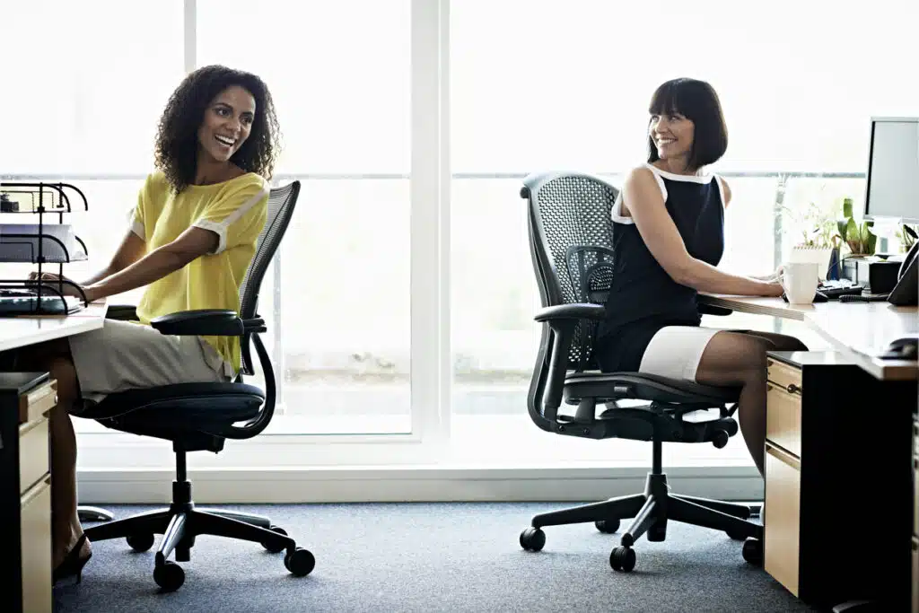 dos-mujeres-riendose-sentadas-en-sillas-de-oficinas-modernas-en-una-oficina