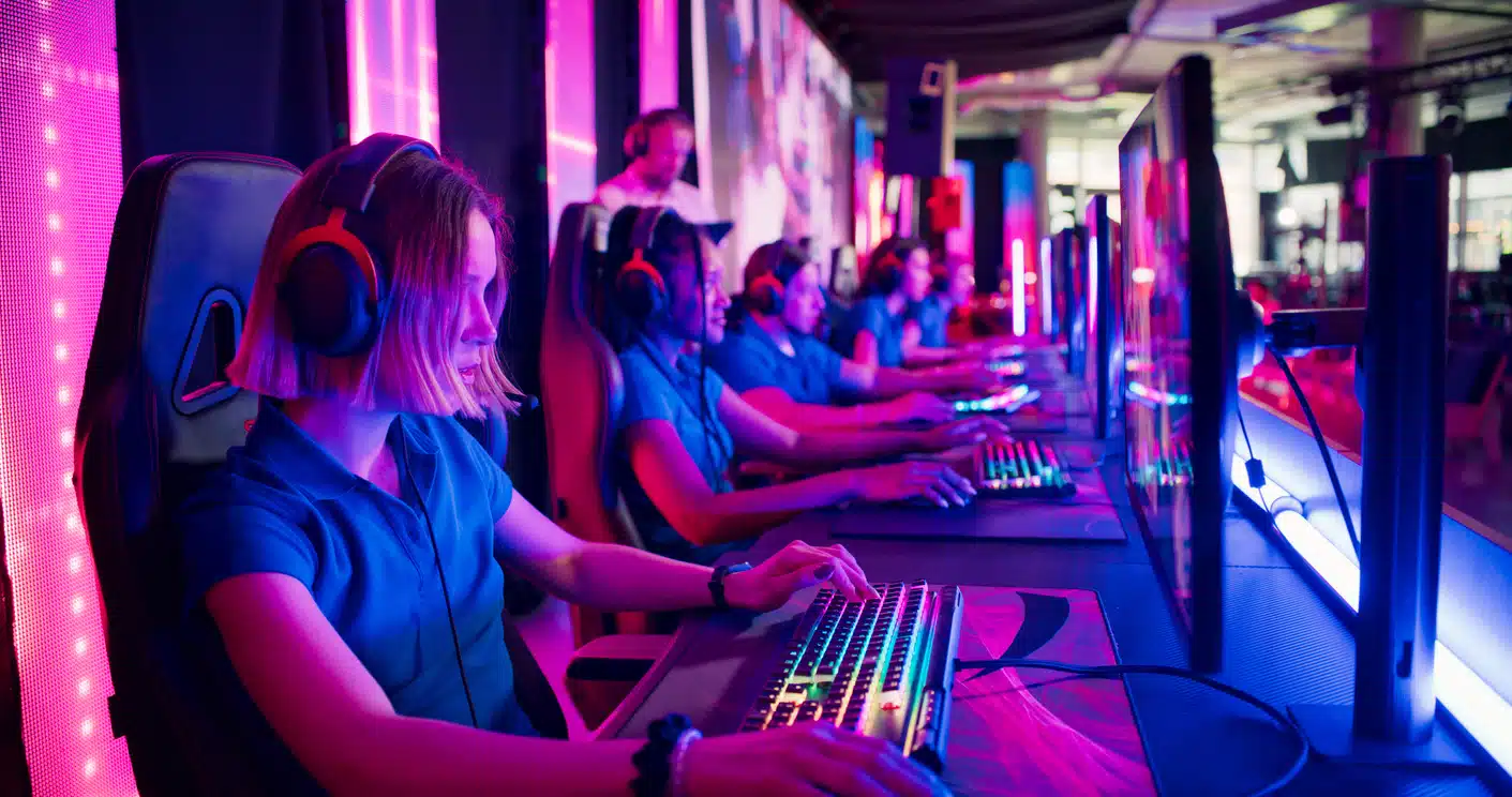 Grupo de gamers diversos jugando a videojuegos sentados en silla gamer de tela