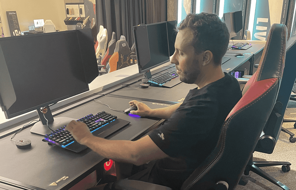 gamer-jugando-con-teclado-mouse-frente-una-pantalla-sentado-en-una-silla-de-juego